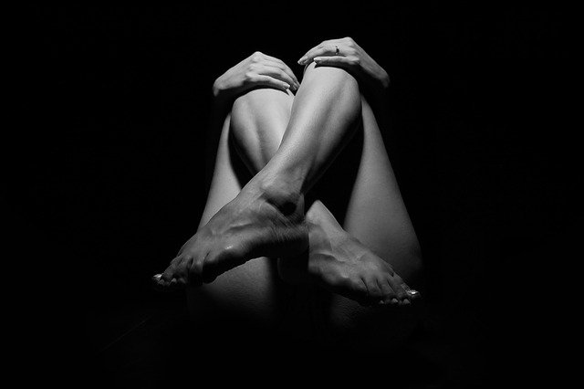 足をクロスしている裸の女性