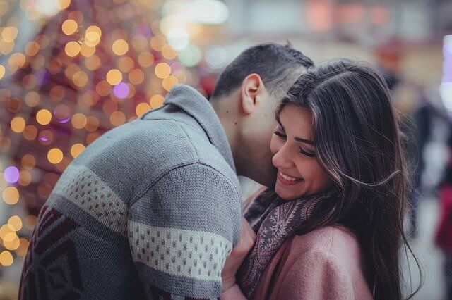 外で女性の頬にキスをしている男性