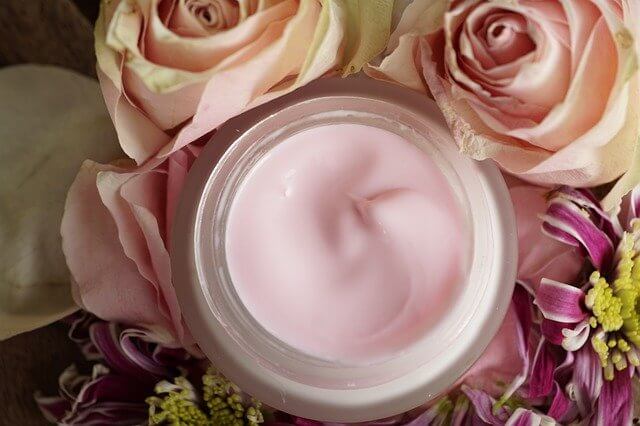 ピンクのバラに囲まれたクリーム
